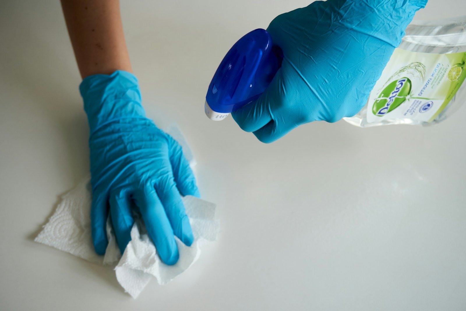 Gloved hand wiping a surface clean